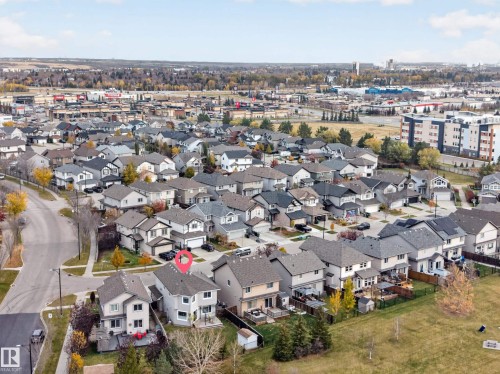 Aerial perspective of a detached residential property featuring a shingle roof, rear-facing deck, and proximity to expansive open green space - 7 Bremner, Fort Saskatchewan, AB 