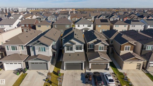 Aerial view featuring multi-story residential structures with pitched asphalt shingle roofing, concrete driveways, and attached multi-car garages - 2045 209A St Nw, Edmonton, AB 