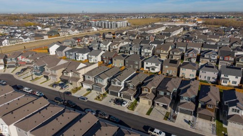 Aerial perspective of a suburban neighborhood featuring paved streets, multi-level residential structures, attached garages, and consistent roofline architecture - 2045 209A St Nw, Edmonton, AB 