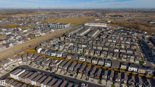 Aerial perspective of a planned suburban residential development featuring multi-level dwellings, grid-patterned streets, concrete driveways, and expansive regional horizon lines - 2045 209A St Nw, Edmonton, AB 