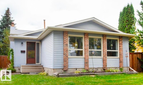 Light blue siding exterior with brick accents, large front windows, and concrete steps leading to the entry door - 8 Ash Crescent, St. Albert, AB 