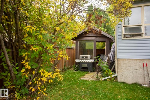 Landscaped yard with a wooden privacy fence, mature trees, and a gazebo - 8 Ash Crescent, St. Albert, AB 