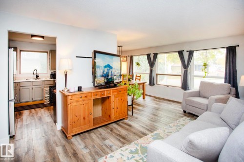 Wood-finish flooring throughout, multiple large windows, and a recessed ceiling light in the kitchen - 8 Ash Crescent, St. Albert, AB 