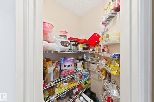 Walk-in pantry featuring white vinyl-coated wire shelving units and wall-mounted storage racks - 4 1920 Millwoods Rd E Nw, Edmonton, AB 