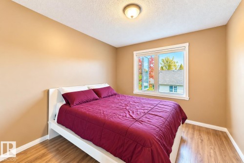 Room featuring wood-finish flooring, a neutral paint palette, and a dual-pane window with white casing - 4 1920 Millwoods Rd E Nw, Edmonton, AB 