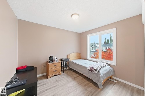 Room featuring wood-finish flooring, a neutral paint palette, and a large window - 4 1920 Millwoods Rd E Nw, Edmonton, AB 