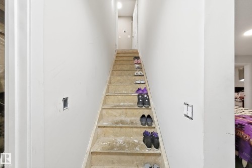 Staircase featuring unfinished wood treads and white-painted drywall - 4 1920 Millwoods Rd E Nw, Edmonton, AB 