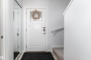 Entryway featuring a paneled door with window, digital lock, mirrored closet doors, and carpeted stairs with a handrail - 6 12815 Cumber Nw, Edmonton, AB 