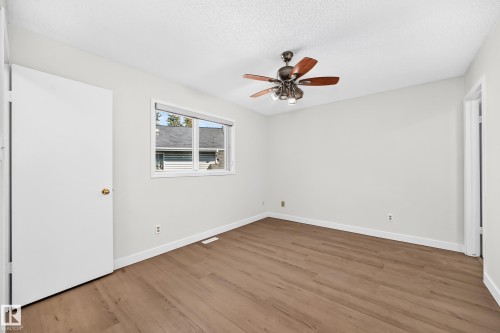 Wood-finish flooring, white walls, white window trim, and a ceiling fan with integrated lighting - 3924 26A Avenue Nw, Edmonton, AB 