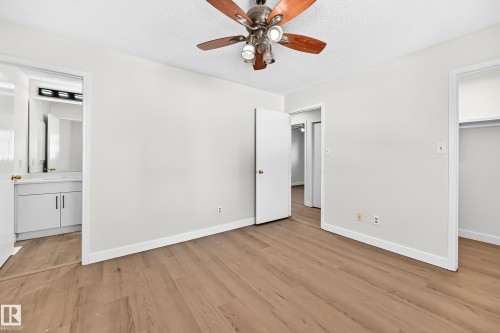 Wood-finish flooring throughout, with a ceiling fan featuring a light kit - 3924 26A Avenue Nw, Edmonton, AB 