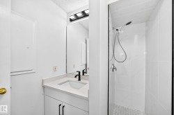 Vanity with a light-toned countertop, integrated sink, and matte black faucet - 