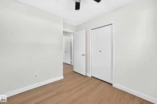 Wood-finish flooring, white walls, white trim, and bi-fold closet doors - 3924 26A Avenue Nw, Edmonton, AB 