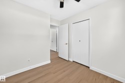 Wood-finish flooring, white walls, white trim, and bi-fold closet doors - 