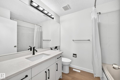 Modern vanity with integrated sink, matte black faucet, and contemporary drawer pulls - 3924 26A Avenue Nw, Edmonton, AB 