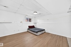 Wood-finish flooring, white walls, and a drop ceiling with recessed lighting - 