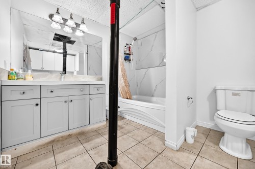 Bathroom featuring a single vanity with gray cabinetry, a white countertop, a mirror, and a white toilet - 3924 26A Avenue Nw, Edmonton, AB 