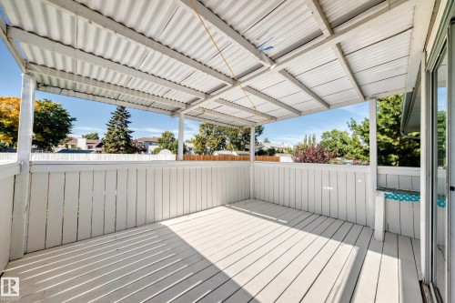 Covered outdoor patio with white wood-finish decking and white wood-finish privacy railing - 3924 26A Avenue Nw, Edmonton, AB 