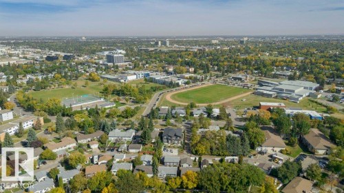 Aerial perspective of a developed urban area featuring residential properties, commercial buildings, green spaces, and athletic fields - 10712 149 Street Nw, Edmonton, AB 