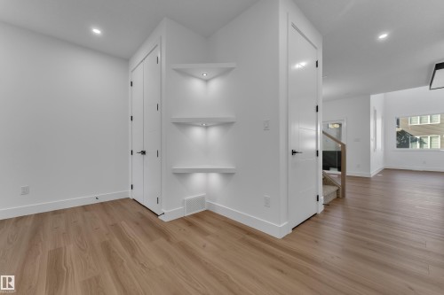 Wood-finish flooring, recessed lighting, built-in shelving with accent lighting, and white trim throughout - 3604 44 Avenue, Beaumont, AB 