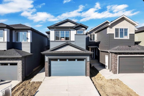 Contemporary residential exterior featuring a multi-tone facade, attached garage, and a concrete driveway - 3604 44 Avenue, Beaumont, AB 