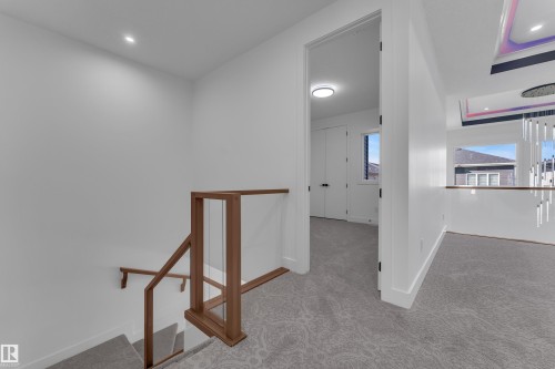 Staircase with wood-finish and glass railing, recessed ceiling lighting, and patterned carpet - 3604 44 Avenue, Beaumont, AB 