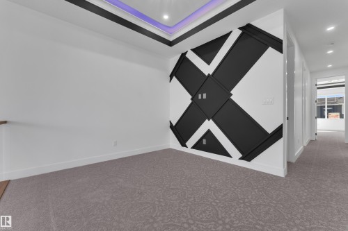 Recessed lighting, tray ceiling with accent lighting, decorative wall paneling, patterned carpeting, and wood-finish flooring - 3604 44 Avenue, Beaumont, AB 