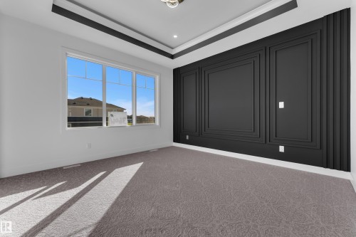 Tray ceiling with recessed lighting, large multi-pane window, wall paneling, and patterned carpeting - 3604 44 Avenue, Beaumont, AB 