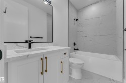 White vanity with gold-tone hardware, rectangular undermount sink, and black faucet - 