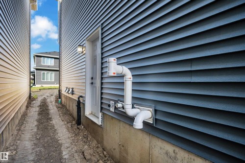 Blue horizontal siding exterior with a white entry door - 3604 44 Avenue, Beaumont, AB 