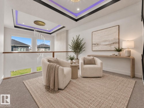 Recessed ceiling with perimeter lighting, contemporary chandelier, glass panel railing with wood-finish top, dual windows, and carpeted flooring - 3604 44 Avenue, Beaumont, AB 