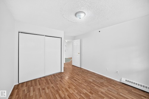 Wood-finish flooring, white walls, and a ceiling-mounted light fixture - #212 11218 80 St Nw, Edmonton, AB 