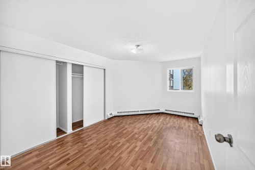 Wood-finish flooring, white walls, and a window with exterior scenery - #212 11218 80 St Nw, Edmonton, AB 