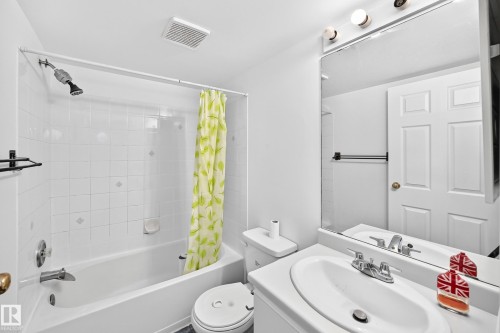 White tile bath/shower combination with a chrome shower head and faucet - #212 11218 80 St Nw, Edmonton, AB 