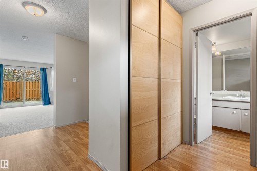 Wood-finish flooring, floor-to-ceiling built-in wood-panel cabinetry, and bathroom featuring a vanity with a rectangular sink - 55 Royal Road Nw, Edmonton, AB 