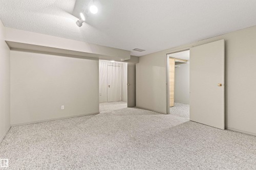 Interior space featuring wall-to-wall carpeting, neutral wall finishes, multi-directional track lighting, and built-in closet storage - 55 Royal Road Nw, Edmonton, AB 