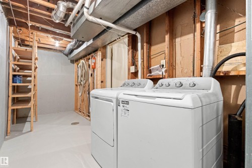 Utility space featuring unfinished wood framing, concrete flooring, and built-in wood shelving - 55 Royal Road Nw, Edmonton, AB 
