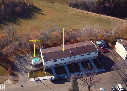 Multi-unit residential exterior featuring asphalt shingle roofing, paved off-street parking, and concrete walkways - 55 Royal Road Nw, Edmonton, AB 
