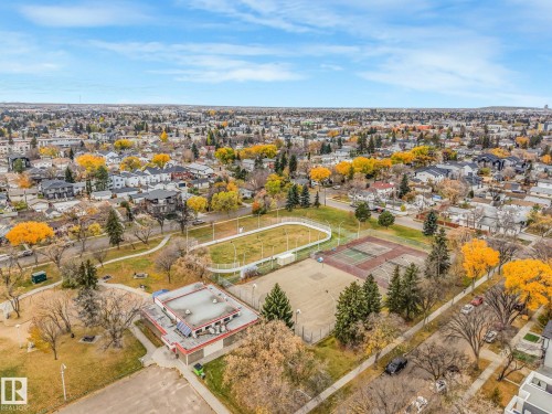 Aerial perspective featuring a park area with fenced tennis courts, a secondary sport court, and a multi-purpose building set within a mature landscape - 9617 151 Street Nw, Edmonton, AB 