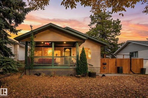 Gable-roof exterior featuring a covered front porch, horizontal siding, lattice skirting, and wood-panel privacy fencing - 9617 151 Street Nw, Edmonton, AB 