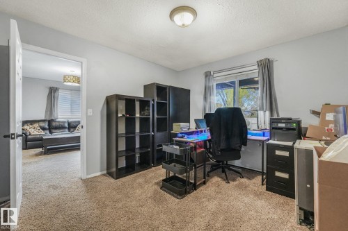 Room featuring neutral-toned carpeting, textured ceiling, and single-pane window with sliding hardware - 9617 151 Street Nw, Edmonton, AB 
