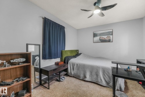 Neutral-toned walls paired with a modern multi-blade ceiling fan featuring an integrated light fixture and wall-to-wall carpeting - 9617 151 Street Nw, Edmonton, AB 