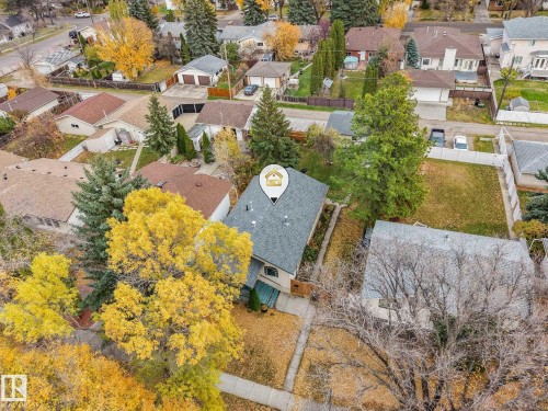 Aerial perspective of a detached property featuring a pitched asphalt shingle roof, mature coniferous and deciduous trees, and grass lawn - 9617 151 Street Nw, Edmonton, AB 