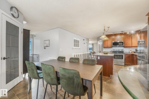 Kitchen featuring wood cabinetry, stainless steel appliances, and a center island - 9617 151 Street Nw, Edmonton, AB 