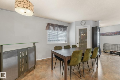 Multi-tonal tile flooring, built-in bar with glass shelving, drum-style pendant lighting, and a single-light French door - 9617 151 Street Nw, Edmonton, AB 