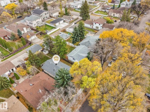 Aerial perspective of a single-family residence featuring a pitched roof, mature evergreen and deciduous trees, and a spacious lot with established landscaping - 9617 151 Street Nw, Edmonton, AB 