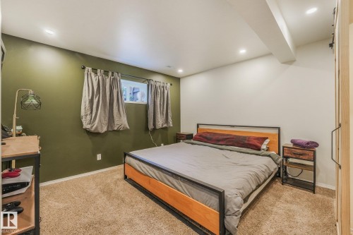 Room interior featuring neutral carpeting, recessed ceiling lighting, and a prominent olive-toned accent wall - 9617 151 Street Nw, Edmonton, AB 