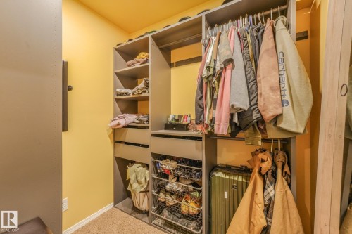 Built-in closet system featuring custom shelving, integrated drawers, metal wire storage baskets, and tiered garment hanging rods - 9617 151 Street Nw, Edmonton, AB 