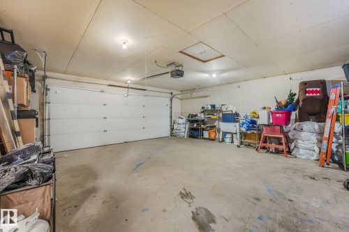 Two-car garage featuring a sectional overhead door, concrete flooring, and ceiling-mounted automated door opener - 9617 151 Street Nw, Edmonton, AB 