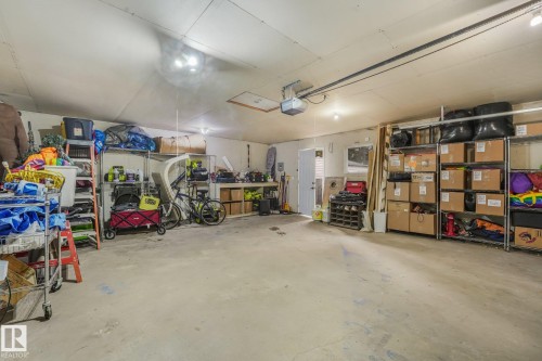 Multi-vehicle garage featuring concrete flooring, integrated ceiling lighting, and a built-in workbench - 9617 151 Street Nw, Edmonton, AB 