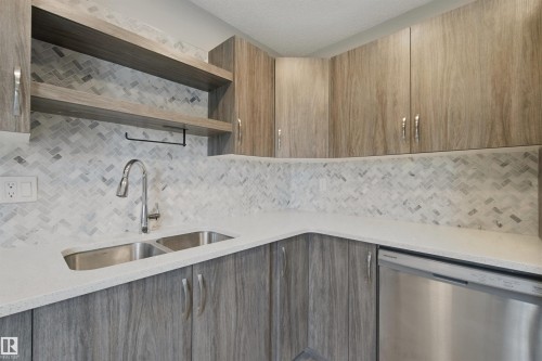 Wood-finish cabinetry and open shelving complement the white countertop and herringbone tile backsplash - 13212 73 Street Nw, Edmonton, AB 